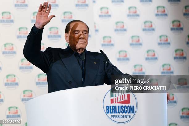 Leader of the Italian right-wing party Forza Italia Silvio Berlusconi salutes supporters as he delivers a speech on stage during a campaign rally in...