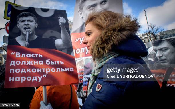 Woman carries a poster during an opposition march in memory of murdered Kremlin critic Boris Nemtsov in central Moscow on February 25, 2018. The...