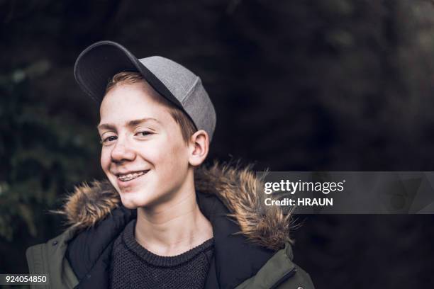 portrait of smiling boy wearing cap in forest - boys with braces stock pictures, royalty-free photos & images