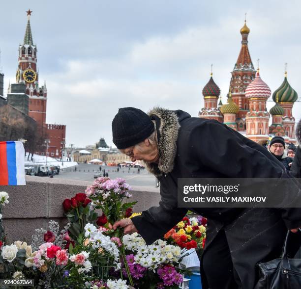 Woman lays flowers in central Moscow on February 25, 2018 at the site where late opposition leader Boris Nemtsov was fatally shot on a bridge near...