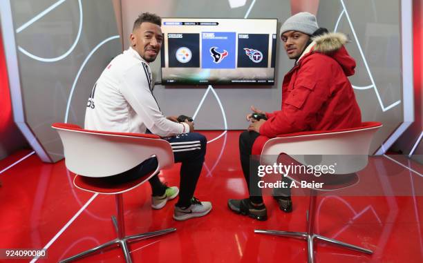 Jerome Boateng of FC Bayern Muenchen and NFL player Deshaun Watson of Houston Texans smile as they play a computer game after a training session at...