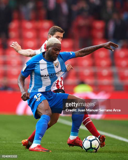 Brown Aide Ideye of Malaga CF competes for the ball with Inigo Martinez of Athletic Club during the La Liga match between Athletic Club Bilbao and...