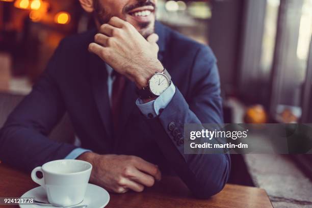 zakenman in café op zoek door het raam - wristwatch stockfoto's en -beelden