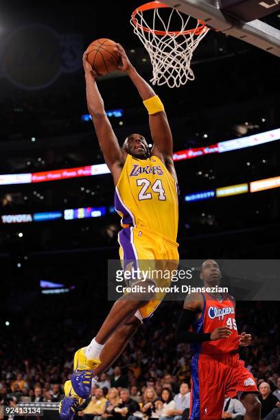 Kobe Bryant of the Los Angeles Lakers goes up for a dunk in front of Rasual Butler of the Los Angeles Clippers in the first quarter of the season...