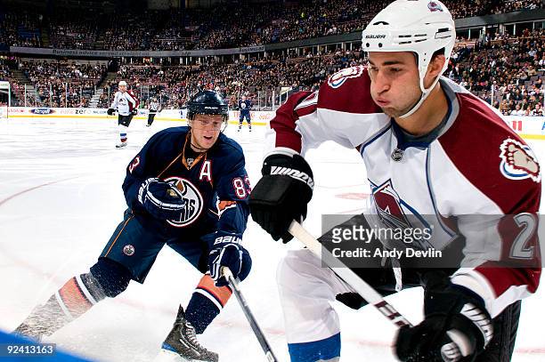 Ales Hemsky of the Edmonton Oilers lines up Kyle Quincey of the Colorado Avalanche for a hit at Rexall Place on October 27, 2009 in Edmonton,...