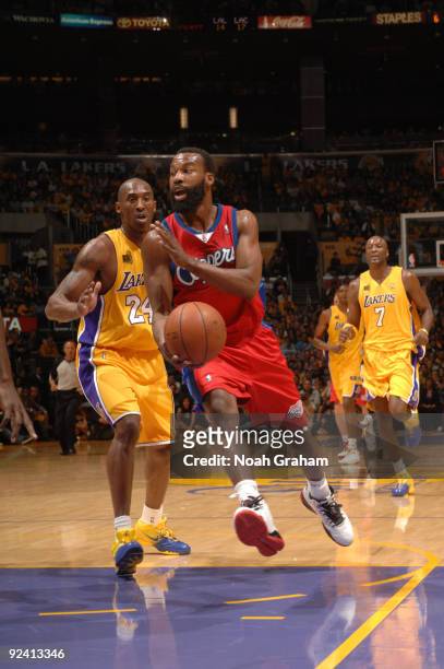 Baron Davis of the Los Angeles Clippers makes a pass against Kobe Bryant of the Los Angeles Lakers in the season opener at Staples Center on October...