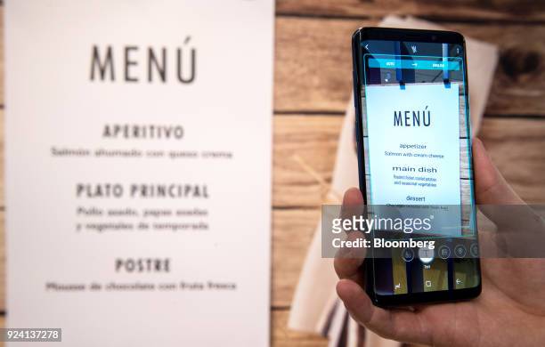 Foreign-language menu hangs on the wall as an attendee demonstrates the live language translation capability of the Galaxy S9 smartphone during a...