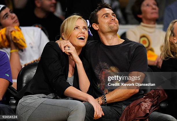 Actors Charlize Theron and Stuart Townsend watch the season opening game between the Los Angeles Clippers and the Los Angeles Lakers at Staples...