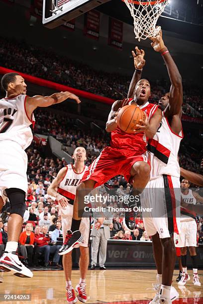 Kyle Lowry of the Houston Rockets goes up for a shot past Greg Oden of the Portland Trail Blazers during the season opening game on October 27, 2009...