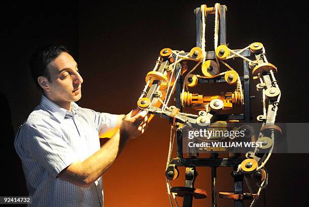 Massimo Ingrosso inspects the complete mechanism of a robot at a Leonardo Da Vinci exhibition titled 'Anatomy to Robots' in Melbourne on October 28 a...