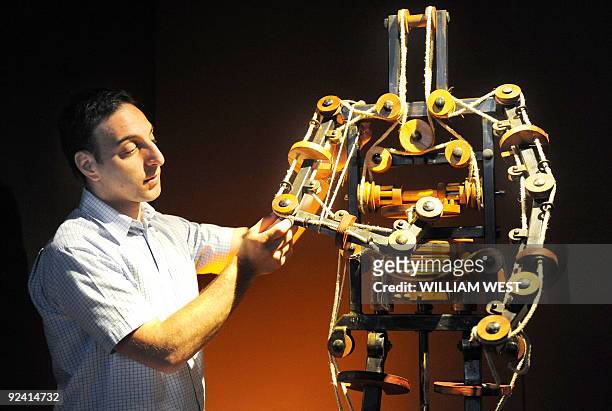 Massimo Ingrosso inspects the complete mechanism of a robot at a Leonardo Da Vinci exhibition titled 'Anatomy to Robots' in Melbourne on October 28 a...