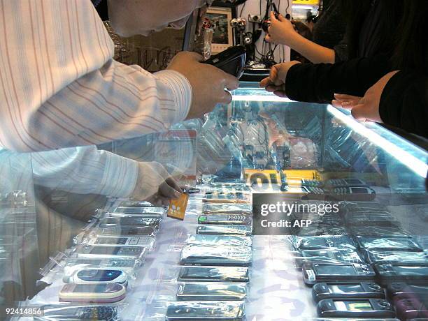 China-telecom-mobile-technology-Apple-iPhone,FOCUS A Chinese vendor sells various 'high imitation' iPhones at a shop in Beijing on October 28, 2009....