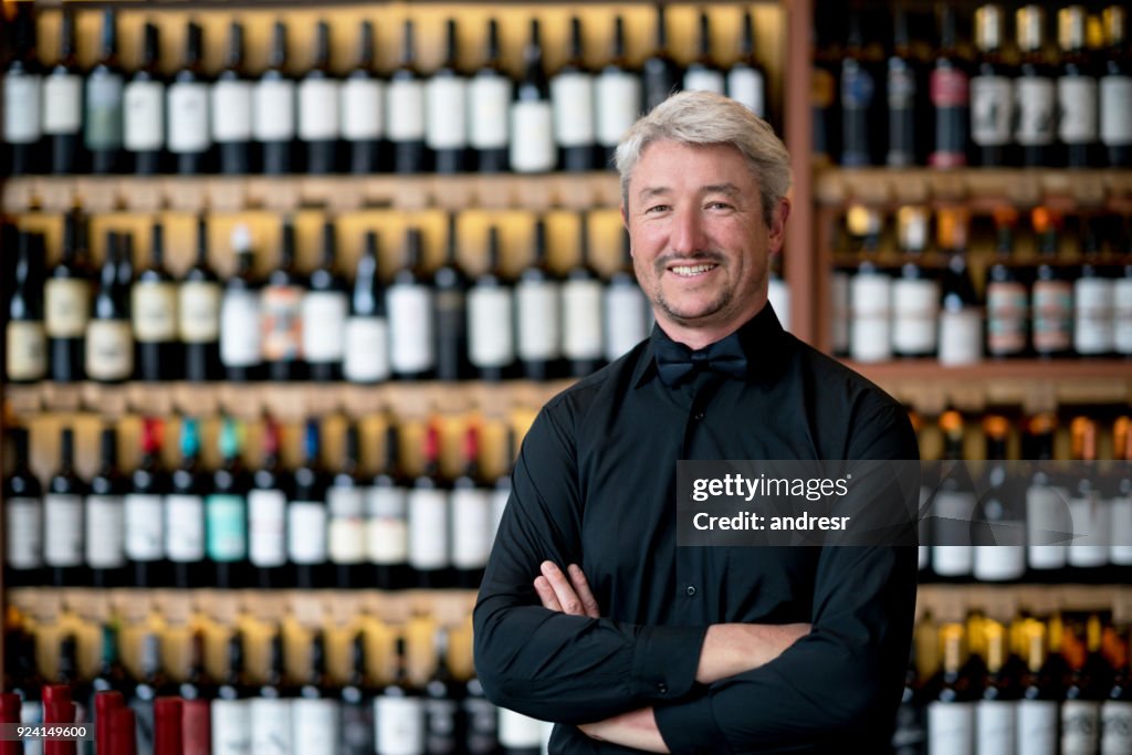 Business owner of a wine store looking at camera smiling with arms crossed