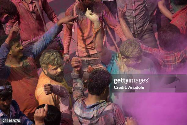 Indians celebrate Holi, the spring festival of colours, during a traditional gathering at Nandbaba temple in Nandgaon village of Mathura district in...