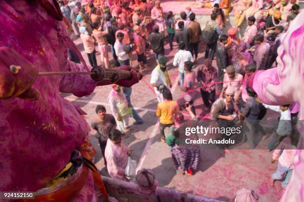 Indians celebrate Holi, the spring festival of colours, during a traditional gathering at Nandbaba temple in Nandgaon village of Mathura district in...