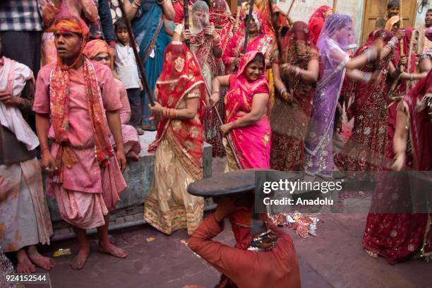 Indian women beat men with stick during celebration of Lathmar Holi in Nandgaon village of Mathura district in Uttar Pradesh, India on February 25,...