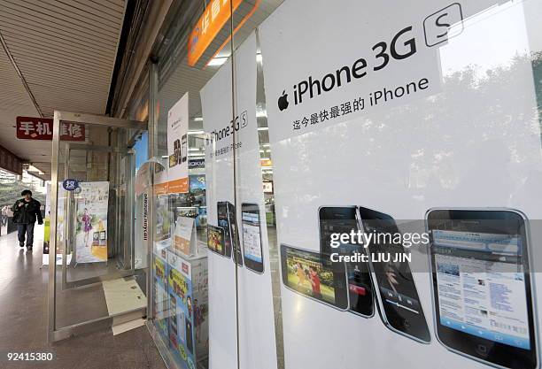 China-telecom-mobile-technology-Apple-iPhone,FOCUS A man walks past posters promoting the Apple iPhones at a store in Beijing on October 28, 2009....