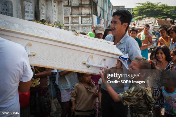 Girl seen crying as she carries a sarcophagus in the navotas cemetery slum. In the center of Pasay District of Metro Manila is a cemetery where over...