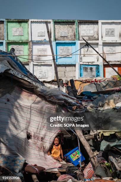 House and children seen in navotas cemetery slum. In the center of Pasay District of Metro Manila is a cemetery where over 10,000 deceased people is...