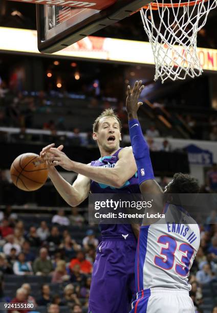 Cody Zeller of the Charlotte Hornets tries to grab a looe ball against James Ennis III of the Detroit Pistons during their game at Spectrum Center on...