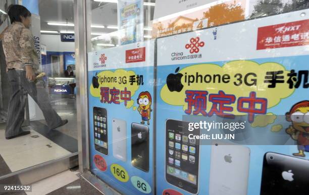 China-telecom-mobile-technology-Apple-iPhone,FOCUS A man walks past posters promoting the Apple iPhones at a store in Beijing in Beijing on October...