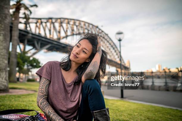 jonge volwassen vrouw hebben een break en geniet naast sydney harbour bridge - tourist sydney stockfoto's en -beelden