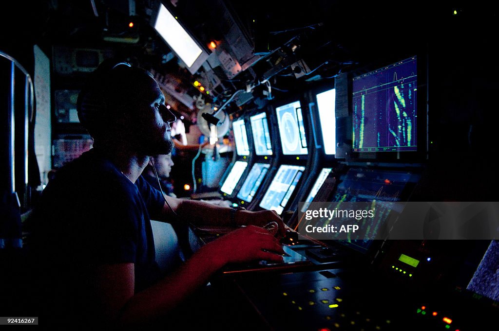 A Submariner Listens To A Sonar In The French SNA Class Submarine a-submariner-listens-to-a-sonar-in-the-french-sna-class-submarine