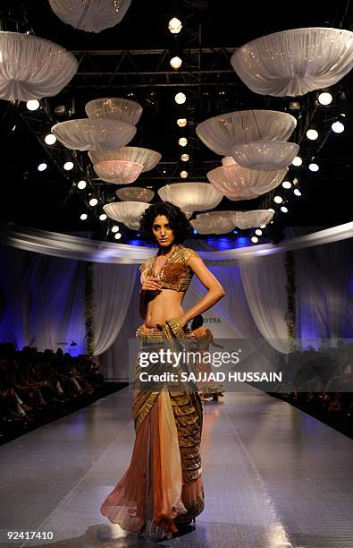 An Indian model displays a creation by Indian designer Manish Malhotra during the third day of the HDIL India Couture Week in Mumbai on October 14,...