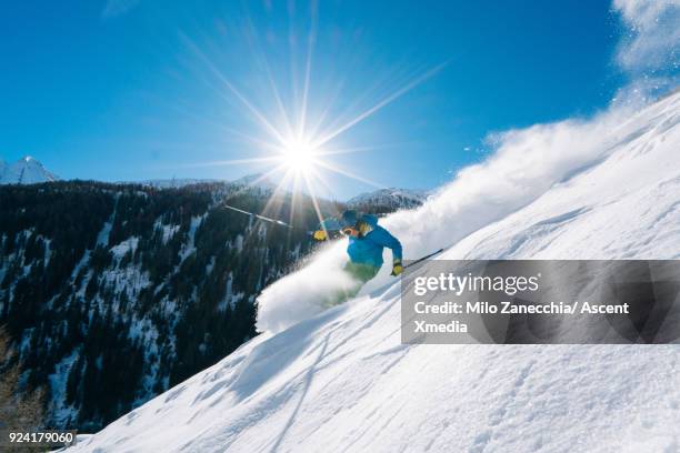 young man skiis above swiss valley after fresh snow - ski pants stock-fotos und bilder