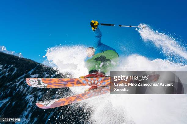 young man in mid air jump above mountains after fresh snow - ski pants stockfoto's en -beelden