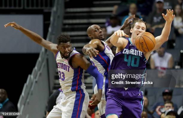 Teammates James Ennis III and Anthony Tolliver of the Detroit Pistons go after a loose ball against Cody Zeller of the Charlotte Hornets during their...