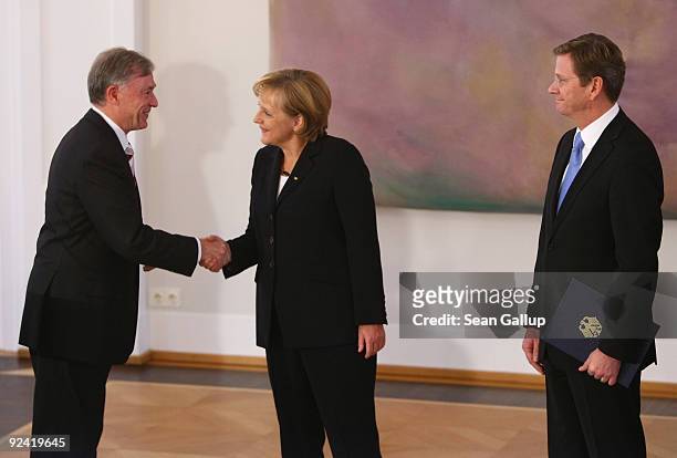 German President Horst Koehler congratulates re-elected German Chancellor Angela Merke as new German Vice Chancellor and Foreign Minister Guido...