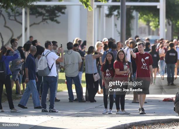 People are seen next to the freshman building where the mass shooting took place at Marjory Stoneman Douglas High School on February 25, 2018 in...