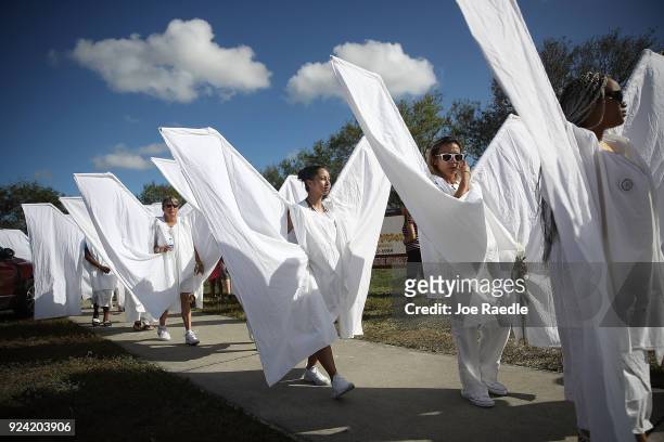 People dressed as angles walk near Marjory Stoneman Douglas High School on February 25, 2018 in Parkland, Florida. Today, students and parents were...