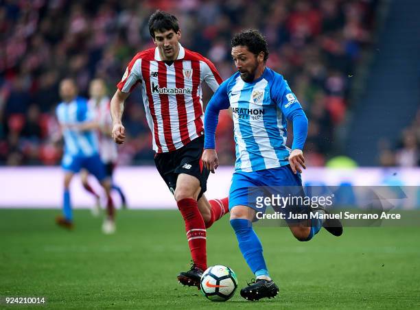 Manuel Rolando Iturra of Malaga CF competes for the ball with Mikel San Jose of Athletic Club during the La Liga match between Athletic Club Bilbao...
