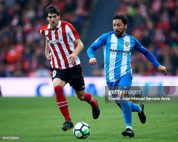 Manuel Rolando Iturra of Malaga CF competes for the ball with Mikel San Jose of Athletic Club during the La Liga match between Athletic Club Bilbao...