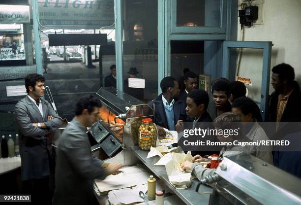 Group of teenagers join the queue at a fish & chip shop in Handsworth, Birmingham, circa 1978.