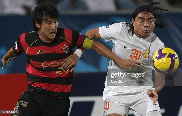 Jae-won Hwang of South Korea's Pohang Steelers club battles for the ball with Qatari Umm Salal club's Brazilian player Davi during their AFC...