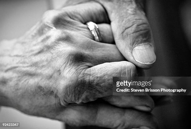 caring hand on senior hand  - black and white holding hands stock pictures, royalty-free photos & images