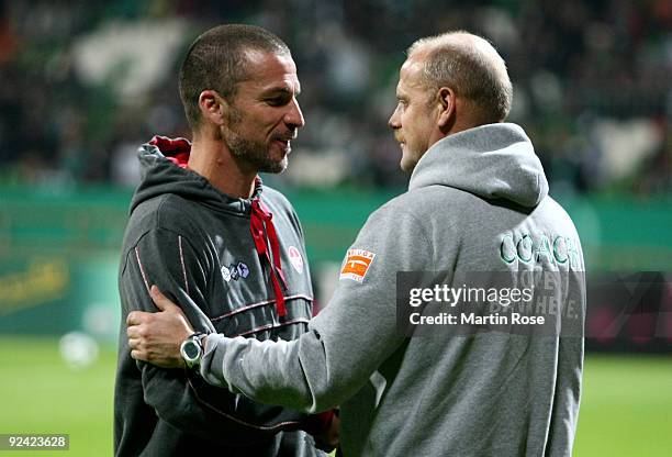 Head coach Marco Kurz of Kaiserslautern talks to head coach Thomas Schaaf of Bremen prior to the DFB Cup third round match between Werder Bremen and...