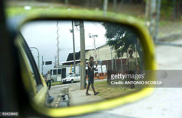 The image of two children behaving apparently under influence of drugs is reflected on a taxi's wing mirror, near the Macacos shantytown, in Rio de...