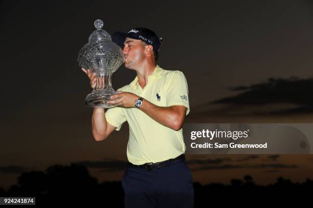 Justin Thomas kisses the winner's trophy after winning a playoff during the final round of the Honda Classic at PGA National Resort and Spa on...