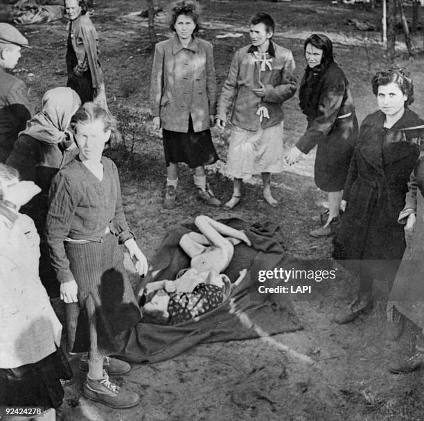 World War II. Bergen-Belsen concentration camp. Women burying a woman starved to death.