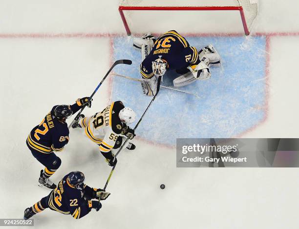 Tim Schaller of the Boston Bruins gets a scoring chance as Chad Johnson, Johan Larsson, and Nathan Beaulieu of the Buffalo Sabres defend during an...