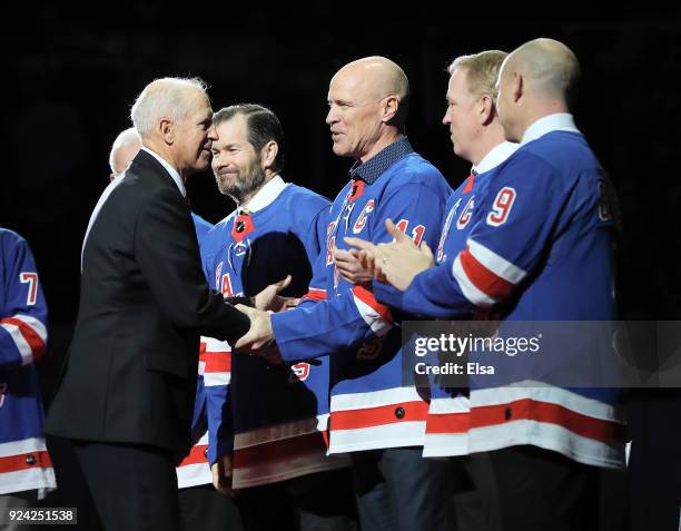 Former New York Rangers Jean Ratelle speaks with former players Mark Messier, Brian Leetch and Adam Graves before Ratelle's jersey retirement...