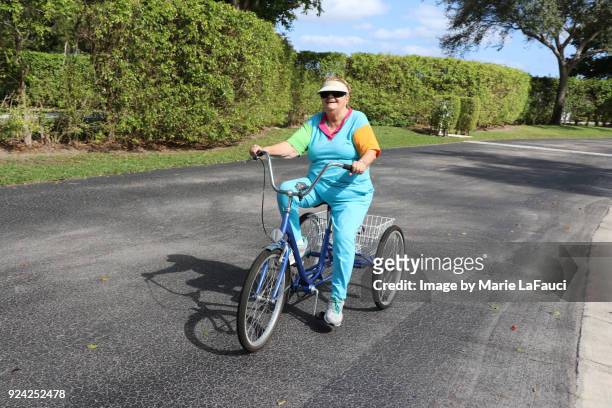 active senior adult riding a three-wheeled bike - boca raton stockfoto's en -beelden