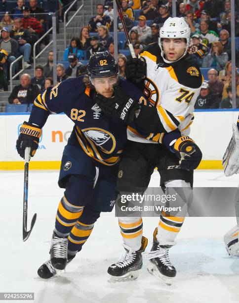 Nathan Beaulieu of the Buffalo Sabres and Jake DeBrusk of the Boston Bruins tangle in front of the net during an NHL game on February 25, 2018 at...