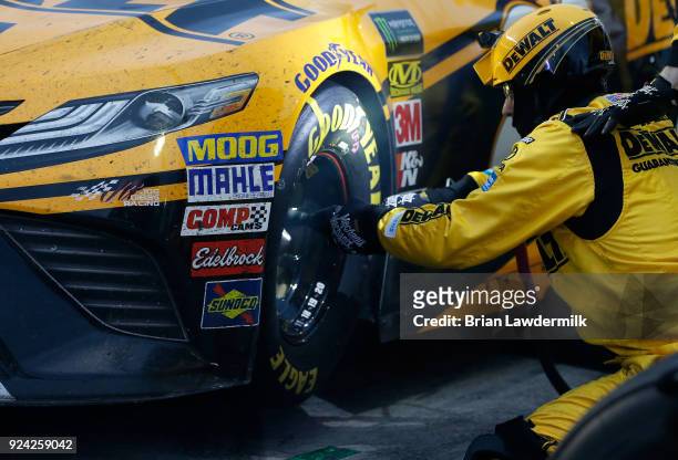 The front tire changer for Erik Jones, driver of the DEWALT Toyota, works to remove lug nuts during the Monster Energy NASCAR Cup Series Folds of...