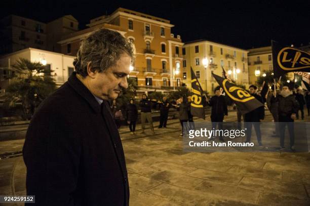 Roberto Fiore, leader of the far-right party Forza Nuova, looks out over an anti-fascist demonstration during a political rally on February 25, 2018...