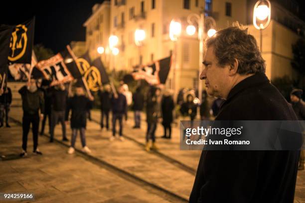 Roberto Fiore, leader of the far-right party Forza Nuova, looks out over an Anti-fascist demonstration during a political rally on February 25, 2018...